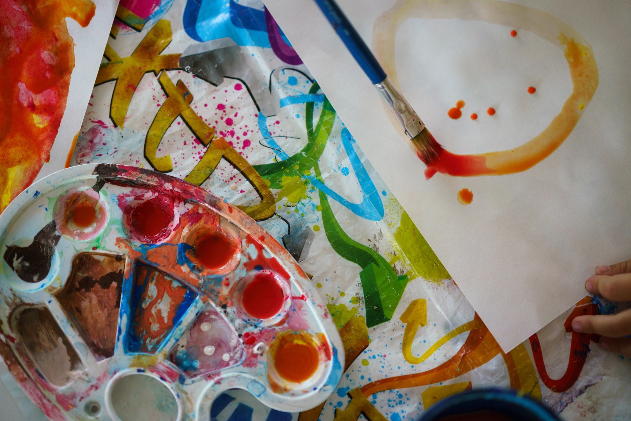 Close-up of paint palette and brush on paper