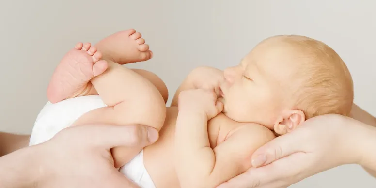 Two babies resting in adult hands