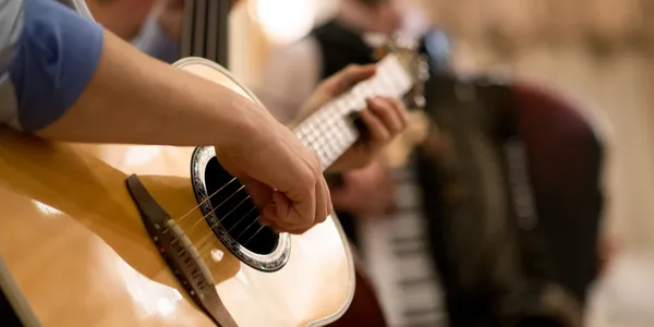 Close-up of a hand strumming an acoustic guitar